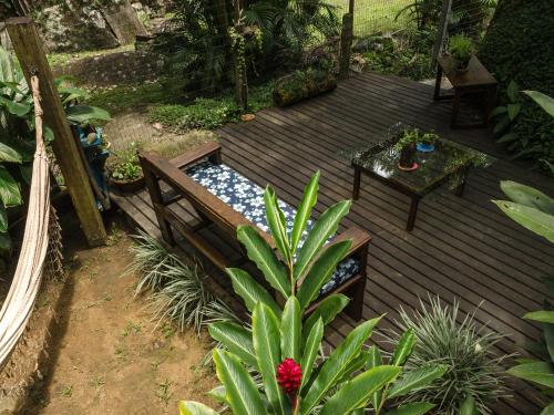a wooden deck with a bench and a table at Kitnet e Suite Morada Aguiar - Chalé in Abraão
