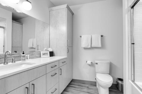 a white bathroom with a toilet and a sink at Golden Poles Chalet #110 in Government Camp