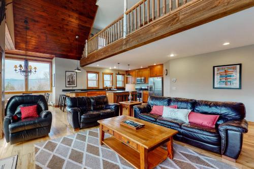 a living room with two leather couches and a table at Thunder Ridge Lodge in Newry