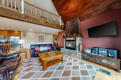 a living room with a fireplace and a tv at Thunder Ridge Lodge in Newry