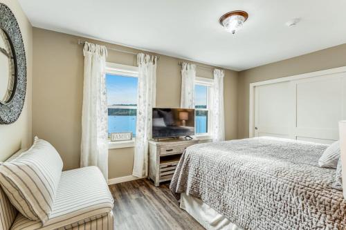 a bedroom with a bed and a tv and a window at Liberty Bay Loft in Poulsbo