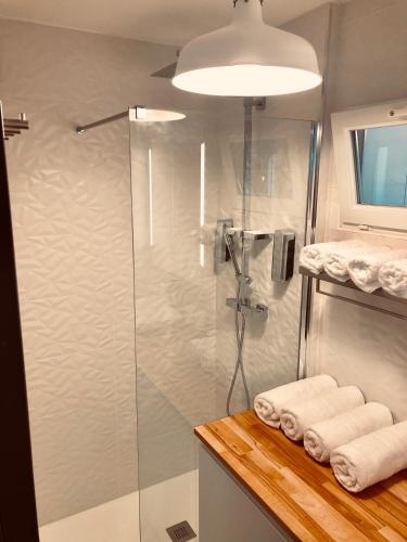 La salle de bains est pourvue d'une douche et de serviettes sur un comptoir. dans l'établissement Chez Alphonse : T3 cosy et rénové - proche du port, à Vannes