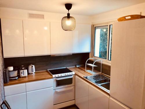 une cuisine avec des armoires blanches et un évier dans l'établissement Chez Alphonse : T3 cosy et rénové - proche du port, à Vannes