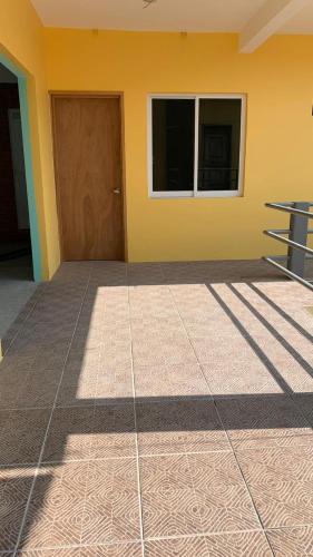 a room with a brown door and a yellow wall at Paziflora Hostel -STARLINK- in Puerto Escondido