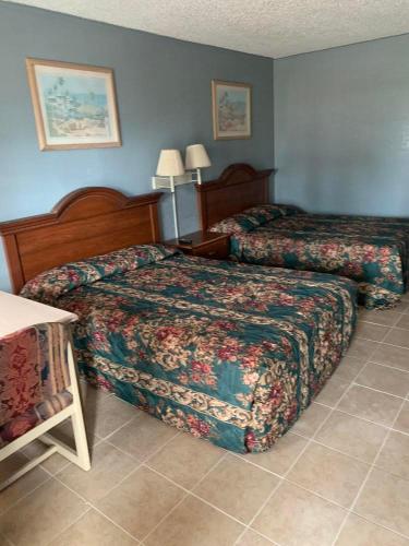 a hotel room with two beds and a table at Executive Inn Mercedes Weslaco in Mercedes