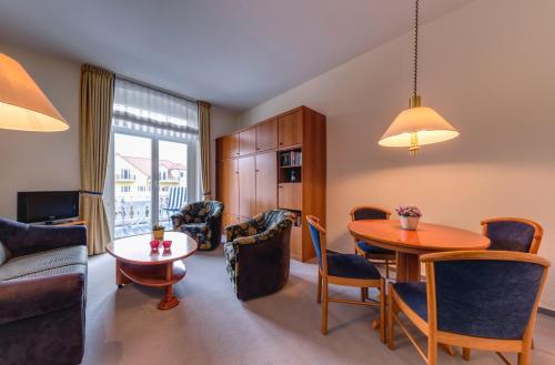 a living room with a table and a dining room at Hotel Aquamarin in Kühlungsborn