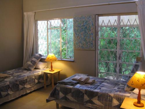 a bedroom with two beds and a window at Seven Falls Lodge in Kloof