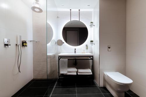 a bathroom with a sink and a toilet and a mirror at The Embassy Valletta Hotel in Valletta