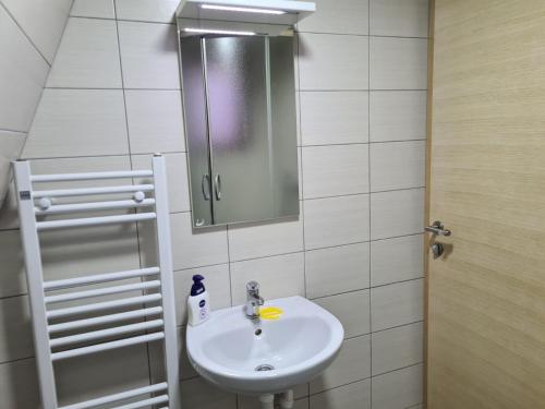 y baño con lavabo y espejo. en KUĆA NENO, en Vlašić