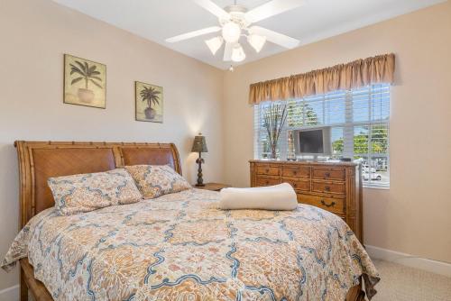 a bedroom with a bed with a ceiling fan and a window at Siesta Avenida Townhome 5208 in Siesta Key