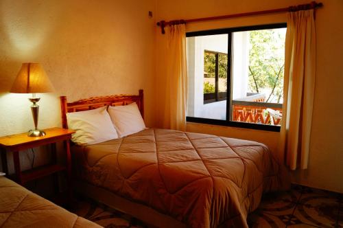 a hotel room with a bed and a window at Hospedaje La Hoja in Tepoztlán