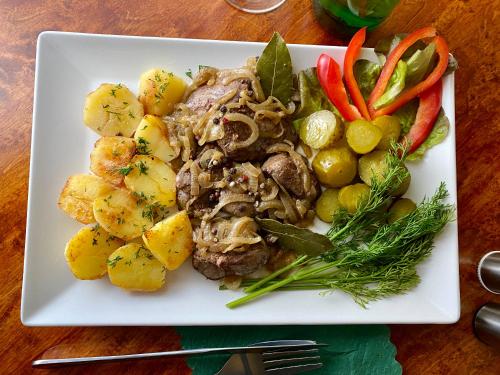 a plate of food with meat potatoes and vegetables at Hotel i Restauracja Castle in Bystrzyca Kłodzka