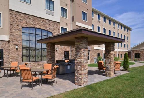 a patio with tables and chairs in front of a building at Staybridge Suites Merrillville by IHG in Merrillville