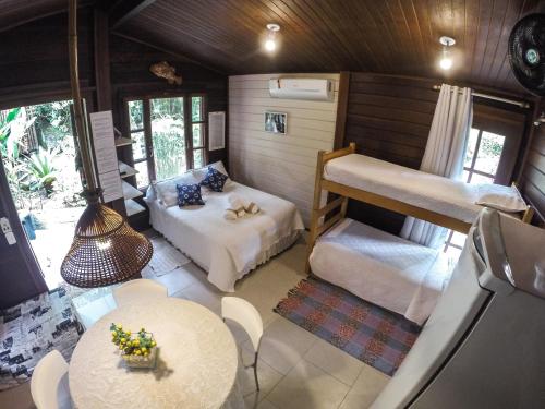 a room with two bunk beds and a table at Kitnet e Suite Morada Aguiar - Chalé in Abraão