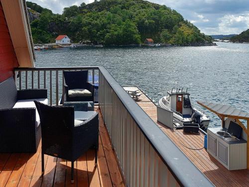 a balcony of a house with a boat on the water at 4 person holiday home in Urangsv g in Ervik