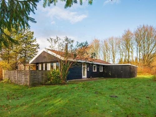 uma pequena casa num quintal com um relvado verde em 6 person holiday home in Toftlund em Toftlund