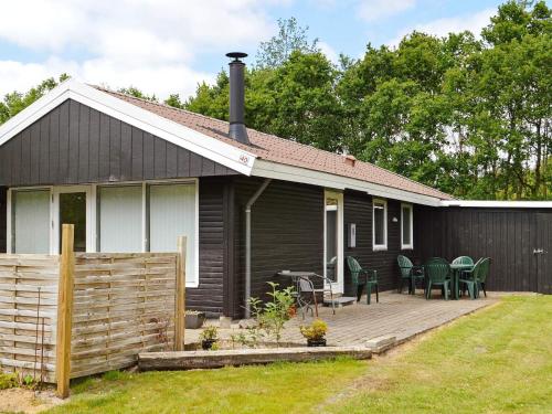 uma casa preta com um deque de madeira no quintal em 6 person holiday home in Toftlund em Toftlund