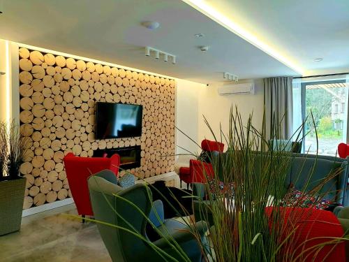 a living room with red chairs and a tv on a wall at Villa Olimpijska 2 - Centrum in Wisła