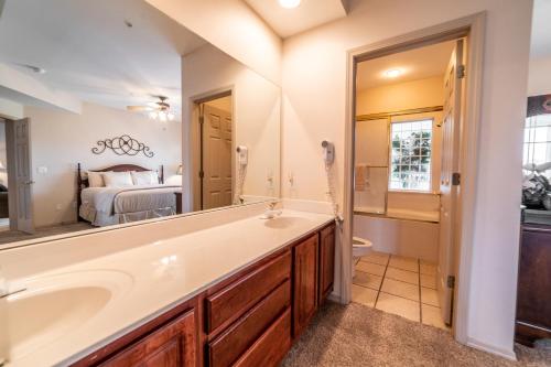 a bathroom with a tub and a sink and a bedroom at Legacy at Thousand Hills in Branson
