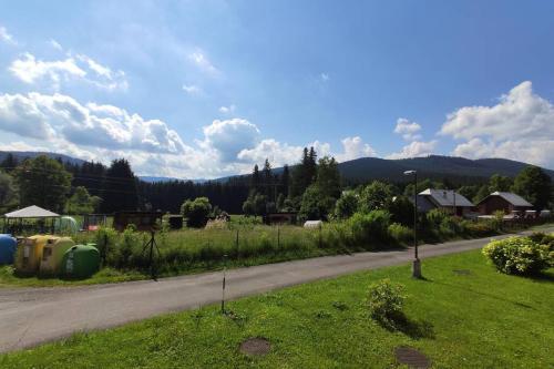 a road with a field of grass next to a street at Apartmán Staré Hamry in Staré Hamry