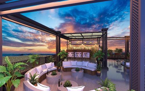 a balcony with a table and white chairs and a sunset at Binh Minh Dien Chau Hotel in Diễn Châu
