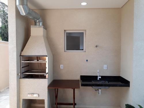 a kitchen with a sink and a stove at LINDO SOBRADO GUARUJÁ in Guarujá