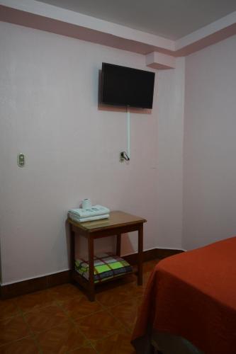 a room with a table and a tv on the wall at Hotel Posada del Centro in Guatemala