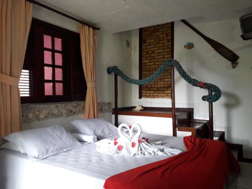 a bedroom with a bed with a bow on it at Hotel O Alemão in Mulungu