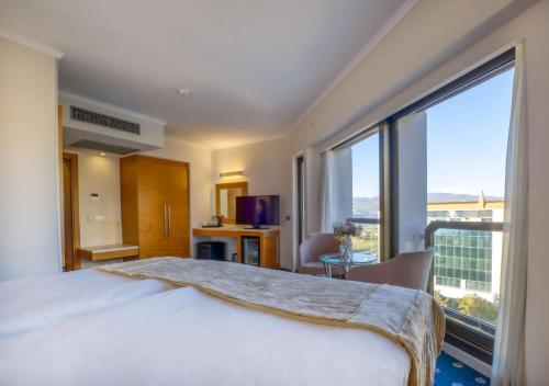 a hotel room with a bed and a large window at Best Western Plus Hotel Konak in Izmir