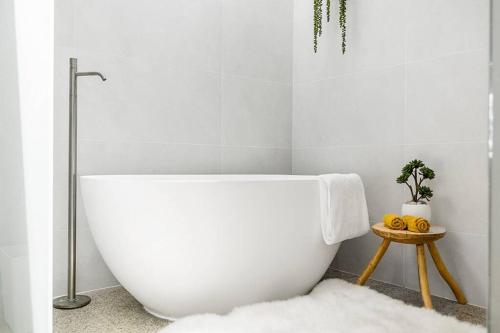 a white bath tub in a bathroom with a rug at The Terrace Penthouse Apartment in Brunswick Heads