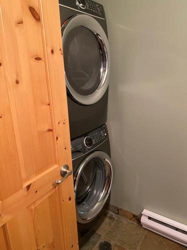 a laundry room with a washing machine and a washer at 3 BR 3 Bath ski in ski out with private hot tub in Big White