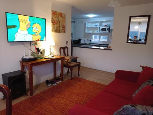 a living room with a couch and a table with a tv at Lomas Papudo 4 in Papudo