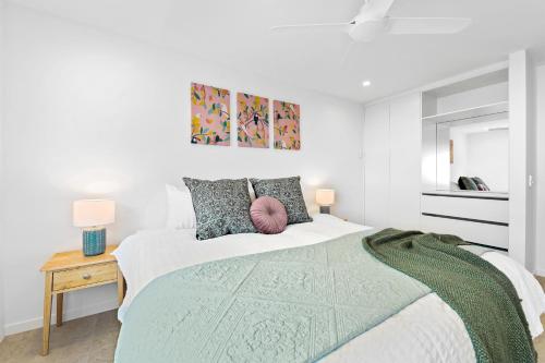 a white bedroom with a bed and a window at Crystal Shores Sunshine Beach in Sunshine Beach
