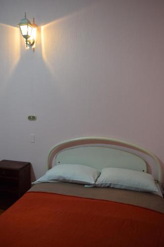 a bedroom with a bed with a light on the wall at Hotel Posada del Centro in Guatemala