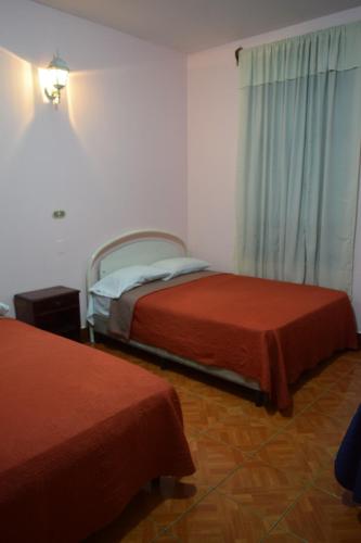 a bedroom with two beds and a window at Hotel Posada del Centro in Guatemala