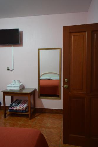 a room with a mirror and a table with a bed at Hotel Posada del Centro in Guatemala