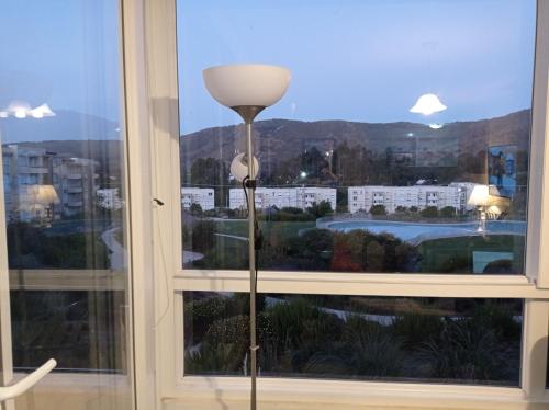 a floor lamp in front of a window at Lomas Papudo 4 in Papudo