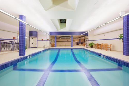 a large indoor swimming pool with blue water at Crowne Plaza Fredericton Lord Beaverbrook, an IHG Hotel in Fredericton