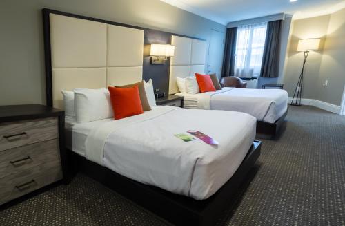 a hotel room with two beds and a chair at Crowne Plaza Fredericton Lord Beaverbrook by IHG in Fredericton