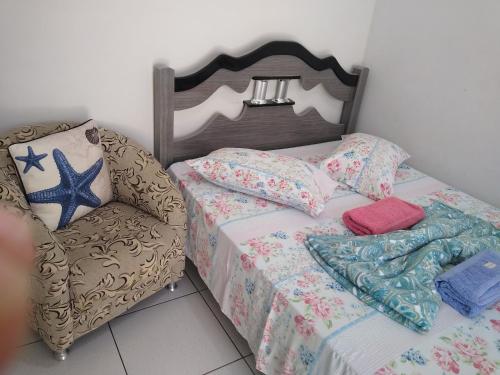 1 dormitorio pequeño con 1 cama y 1 silla en Suítes Para Casal en Bertioga