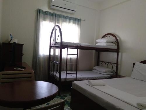 um pequeno quarto com 2 beliches e uma mesa em Watermoon Beach Resort em Lian