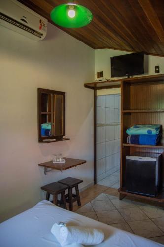 a bedroom with a bed and a green light at Pousada Bob Pai & Bob Filho in Ilha do Mel