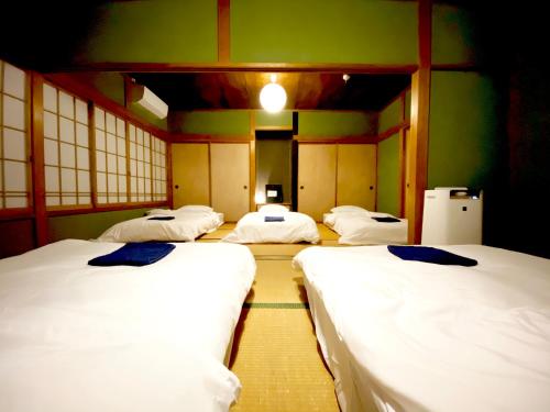 - 4 lits dans une chambre aux murs verts dans l'établissement 湊庵錆御納戸-so-an sabionand-, à Inatori