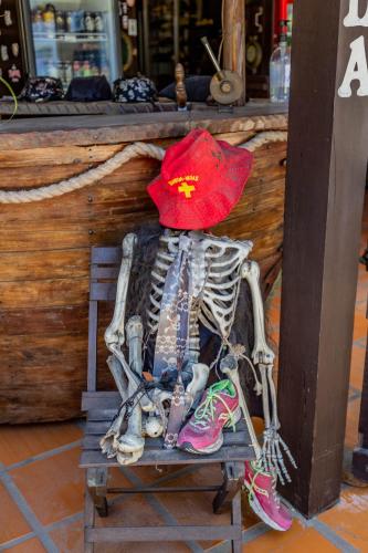 a skeleton with a red hat sitting on a stool at Pousada Bob Pai & Bob Filho in Ilha do Mel