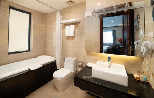 a bathroom with a sink and a toilet and a tub at Hanoi Larosa Hotel in Hanoi