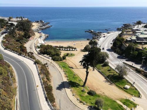 DEPARTAMENTO FRENTE A LA PLAYA 3 personas في فالبارايسو: اطلالة جوية على طريق بجانب شاطئ