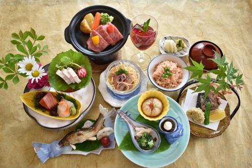 Shiobara Onsen Tokiwa Hotel في ناسوشيوبارا: طاولة عليها العديد من أطباق الطعام