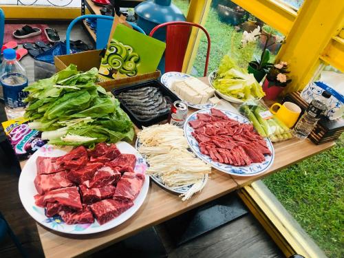 a table with three plates of meat and vegetables at 宜蘭81 Boat輕旅 寵物友善 小團體包棟 獨棟villa in Jiaoxi