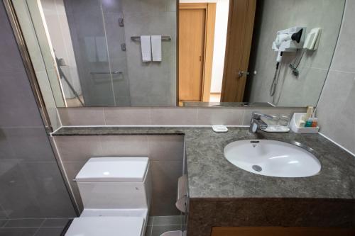a bathroom with a sink and a toilet and a mirror at The K Hotel Gyeongju in Gyeongju