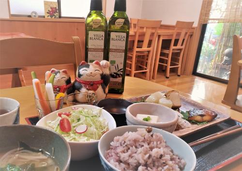 a table topped with bowls of food next to a bottle of wine at Ryokan Shimizu in Kyoto